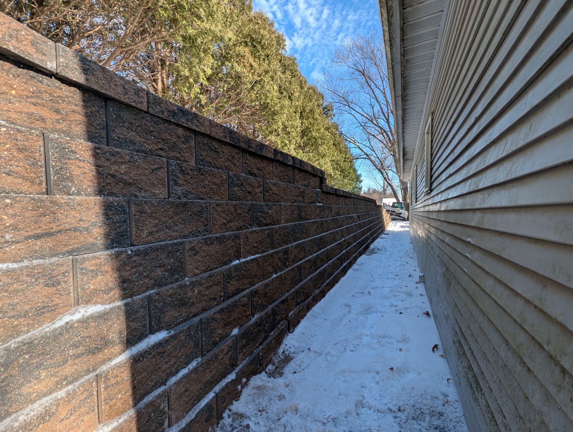 Brick retaining wall lining a stone walkway Brick retaining wall lining a stone walkway
