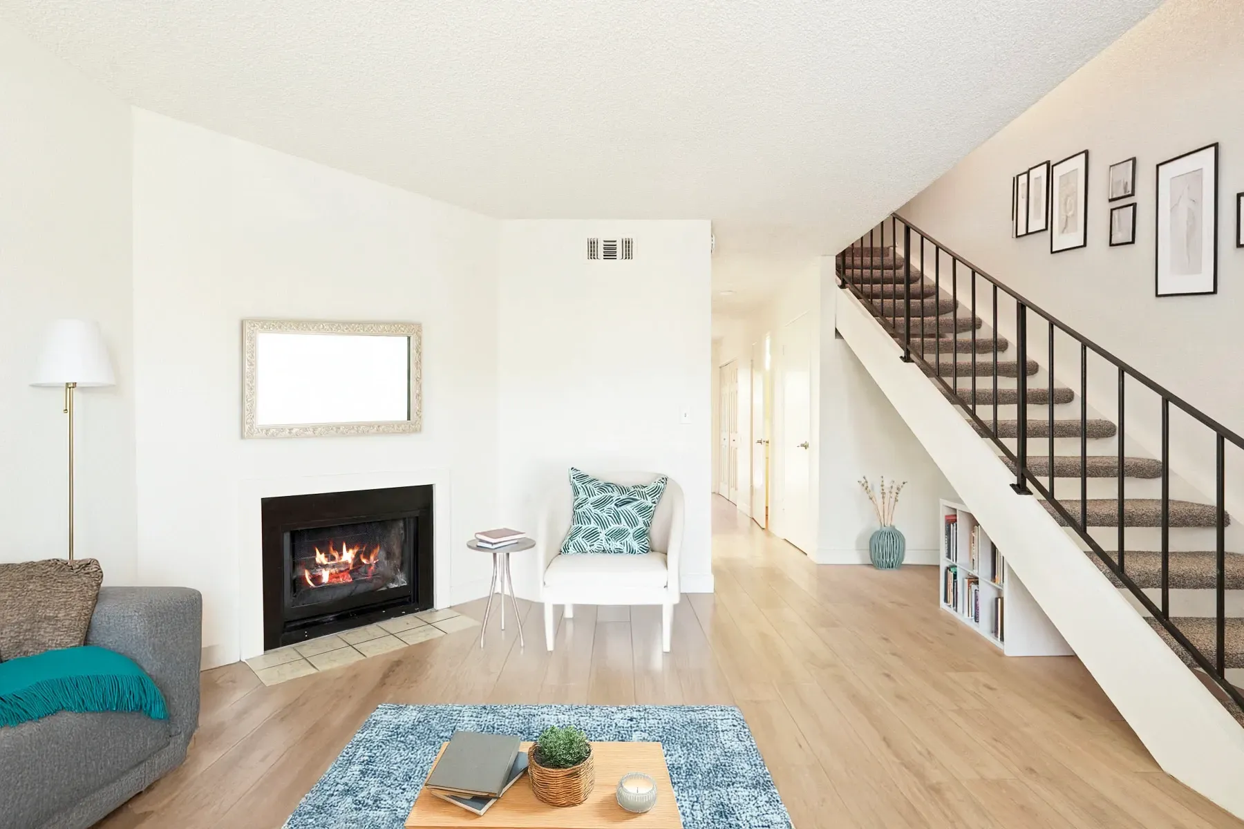 Spacious living area with a fireplace and staircase.
