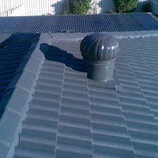 A roof with a ventilation fan on top of it.