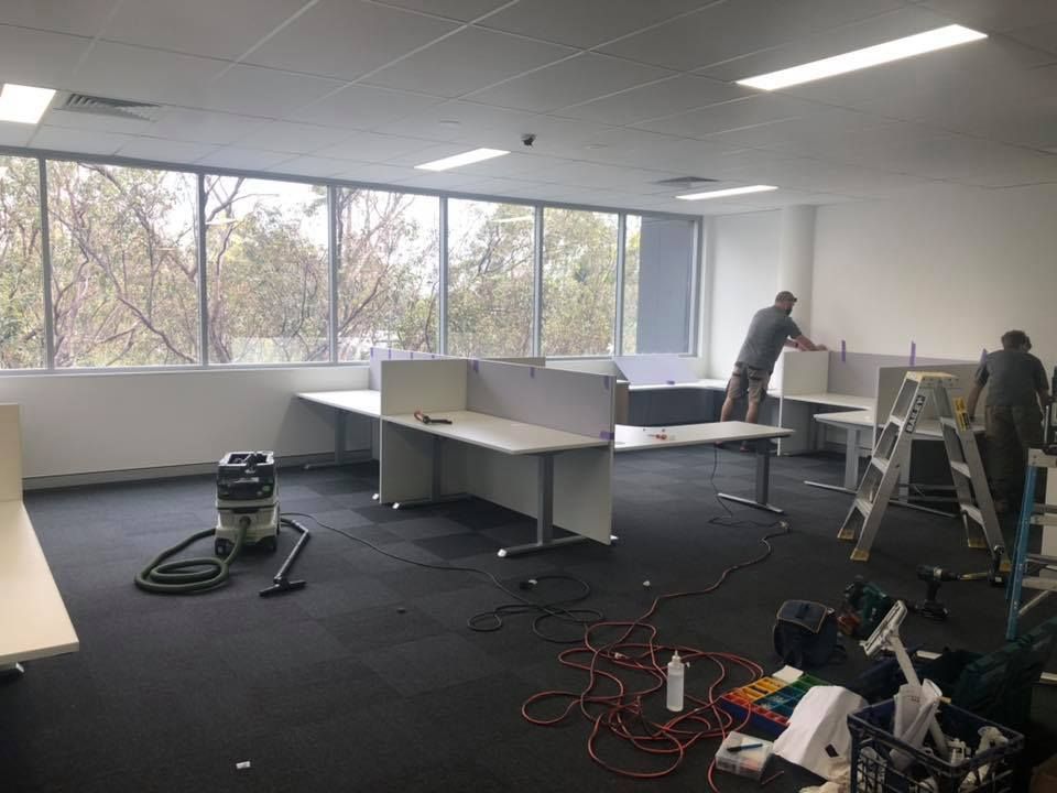 A Man Is Working On A Desk In An Office — Logic Joinery In Fountaindale, NSW