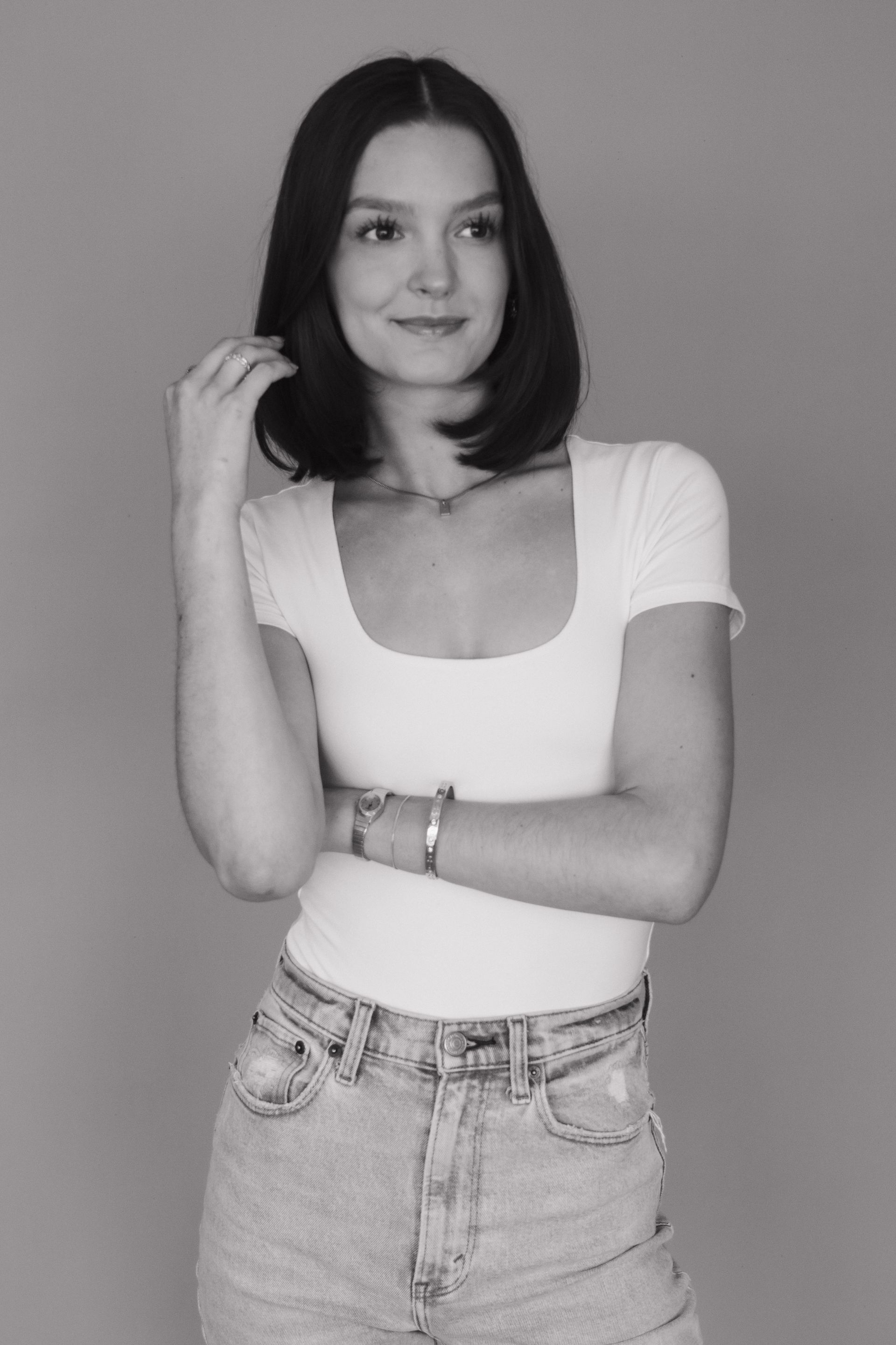A black and white photo of a woman in a white shirt and jeans.