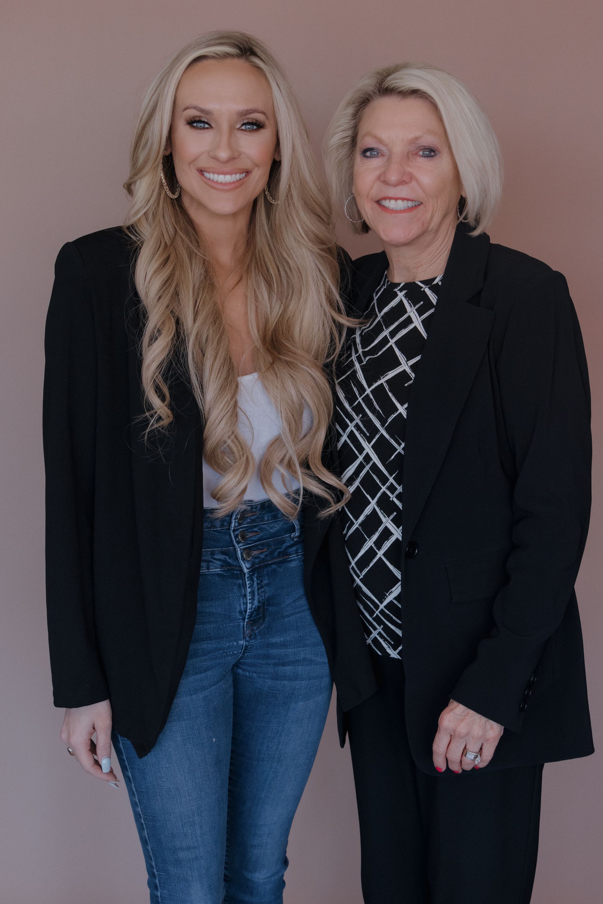 Two women are standing next to each other and smiling for the camera.