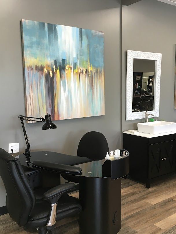 There is a painting on the wall above the desk in the room.