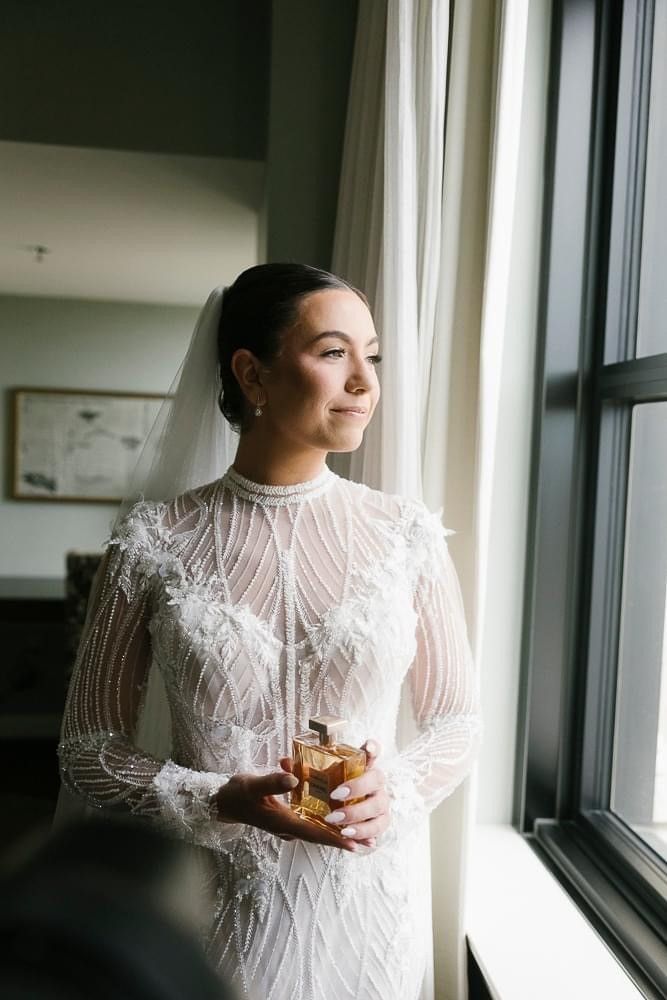 A woman is sitting in a chair holding a mirror.