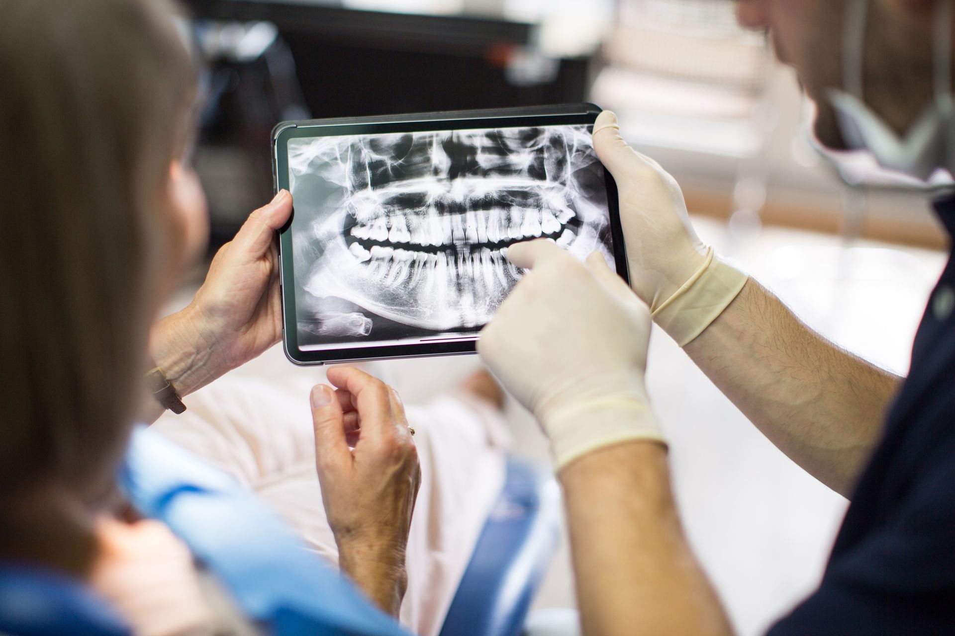 Dentist examining a patient's teeth in a dental office.