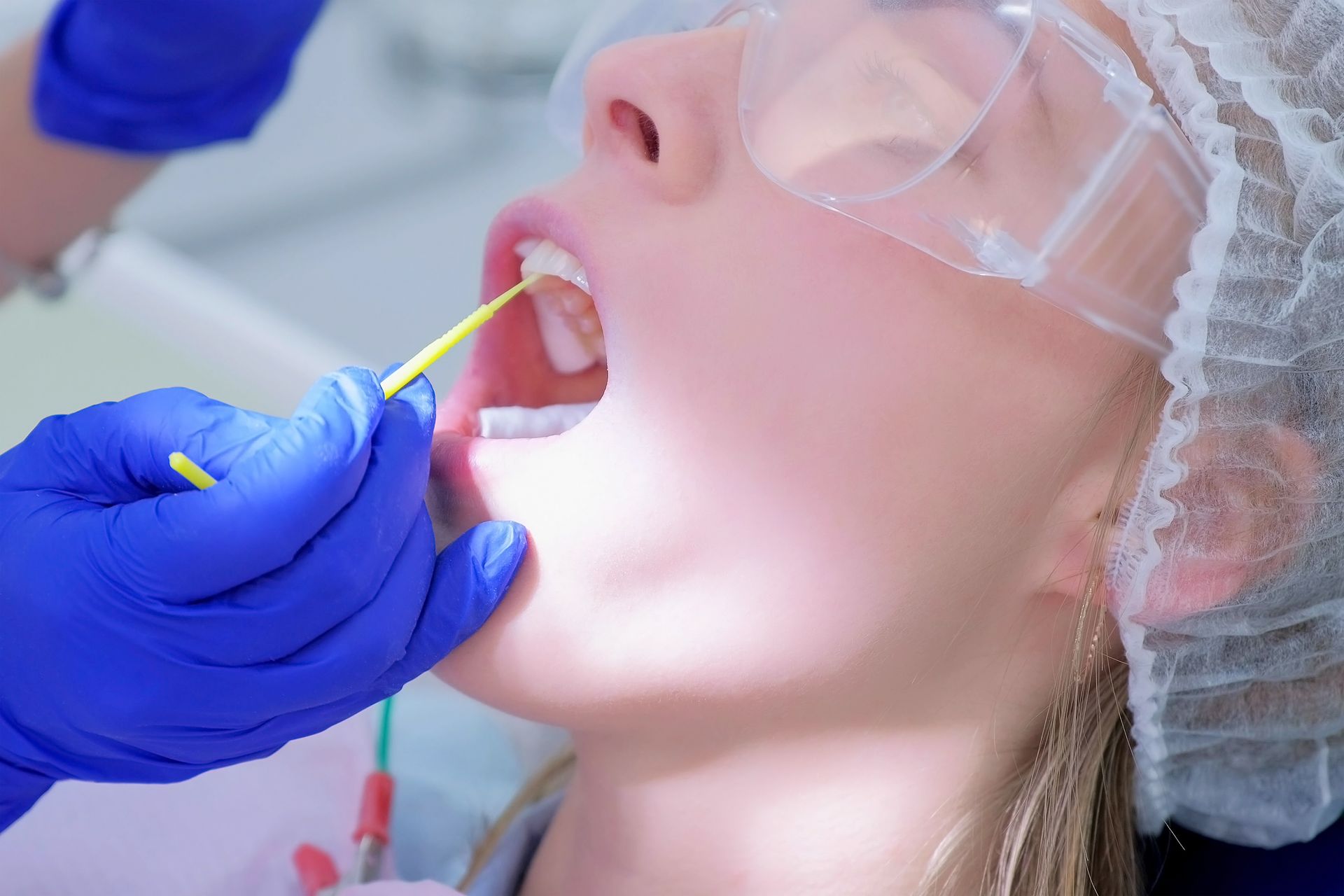 Dentist examining patient's teeth with a small tool; close-up view.