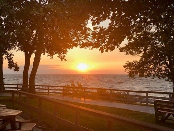 Dentist's office with a white dental chair and a smaller stool. Bright, clean space with medical equipment.