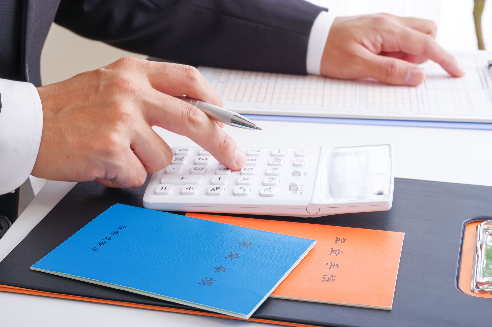 A man is using a calculator to check some numbers.