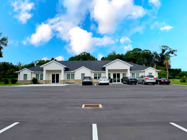 A white house with cars parked in front of it