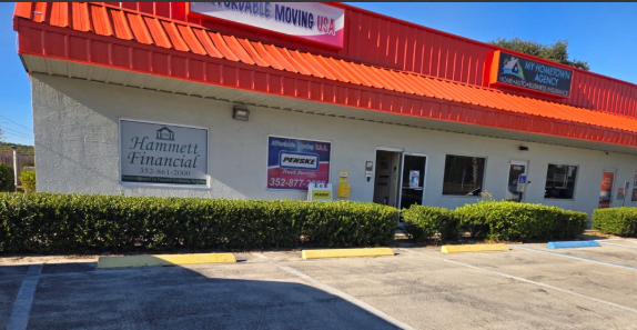 A white house with cars parked in front of it