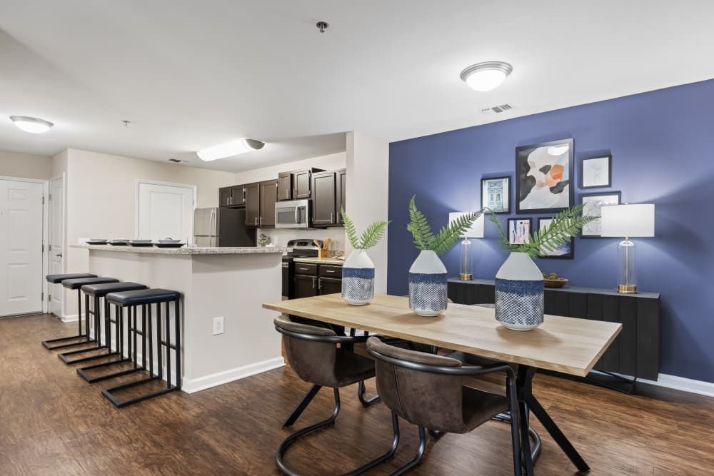 a dining room with a table and chairs and a blue wall at Marquis on Cary Parkway in Morrisville, NC.