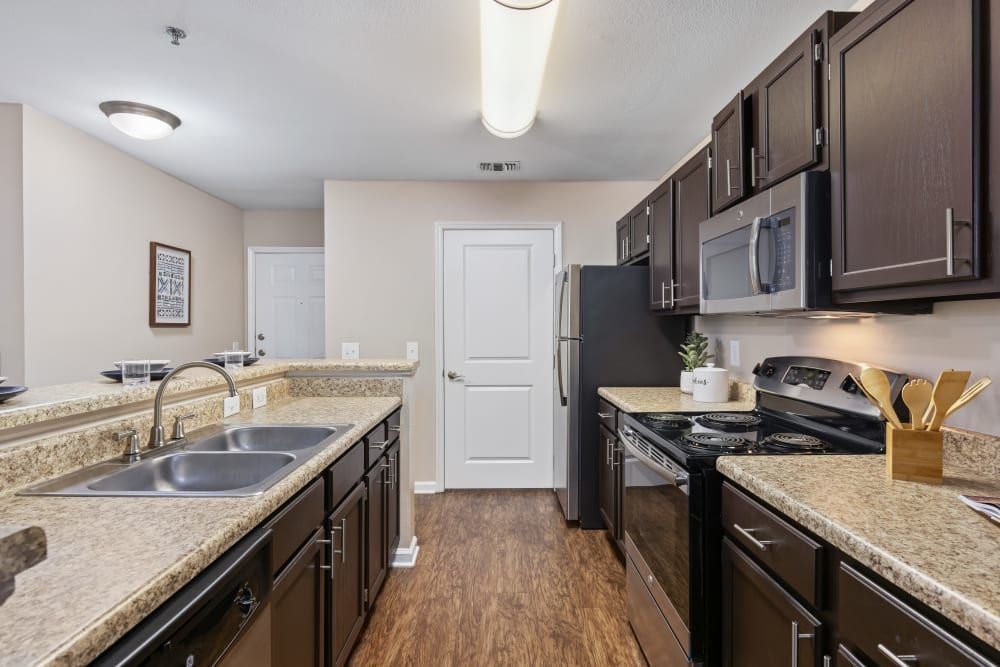 a kitchen with stainless steel appliances and granite counter tops at Marquis on Cary Parkway in Morrisville, NC.