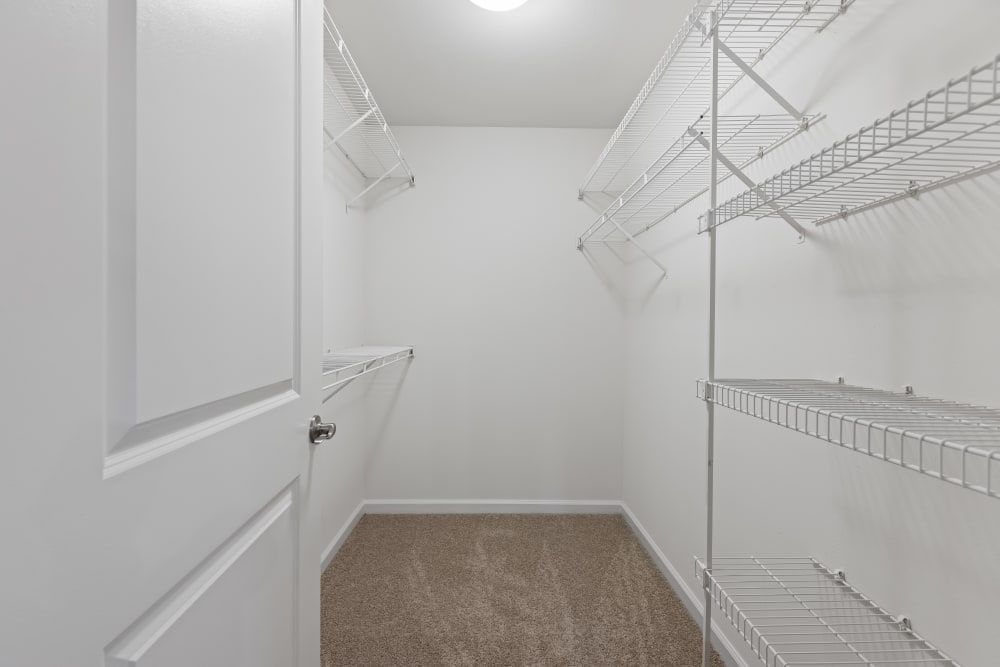 a walk-in closet with lots of shelves and a door at Marquis on Cary Parkway in Morrisville, NC.