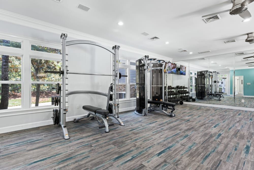 a large gym with a lot of equipment and a large mirror at Marquis on Cary Parkway in Morrisville, NC.