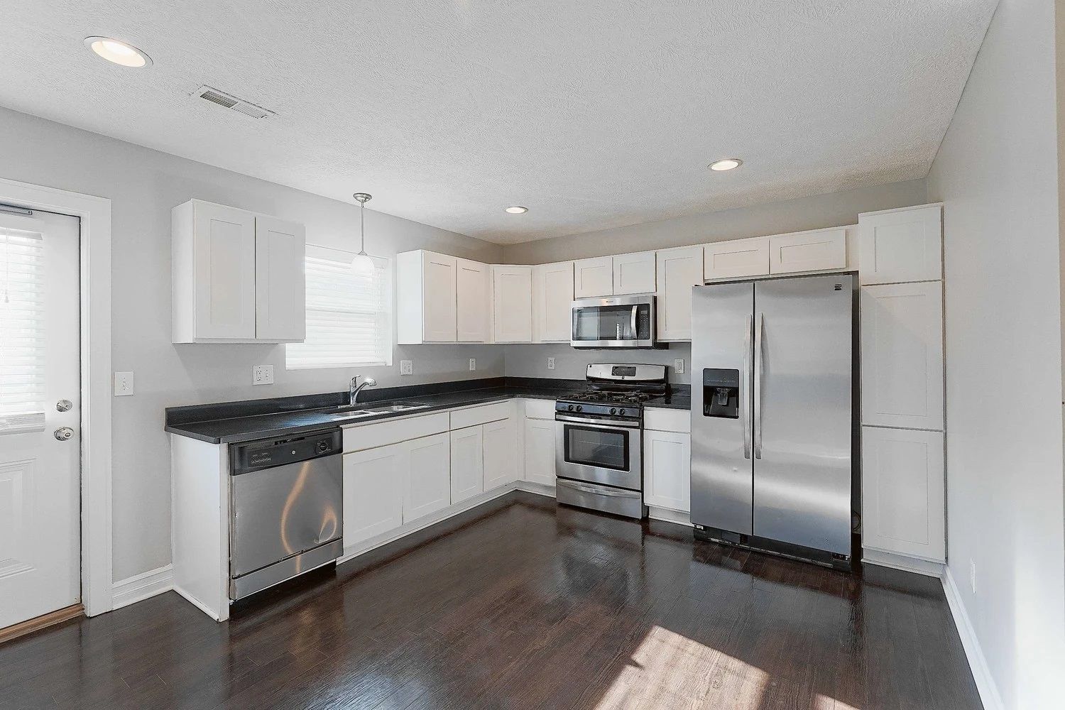 A kitchen with stainless steel appliances and white cabinets