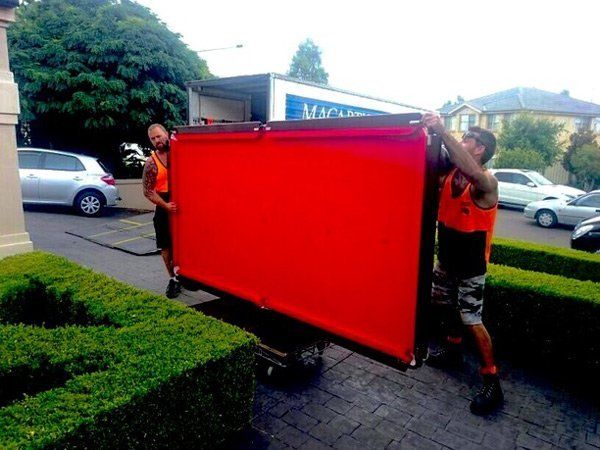 two men moving a pool table