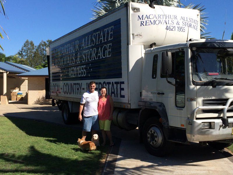man and woman in front of company truck