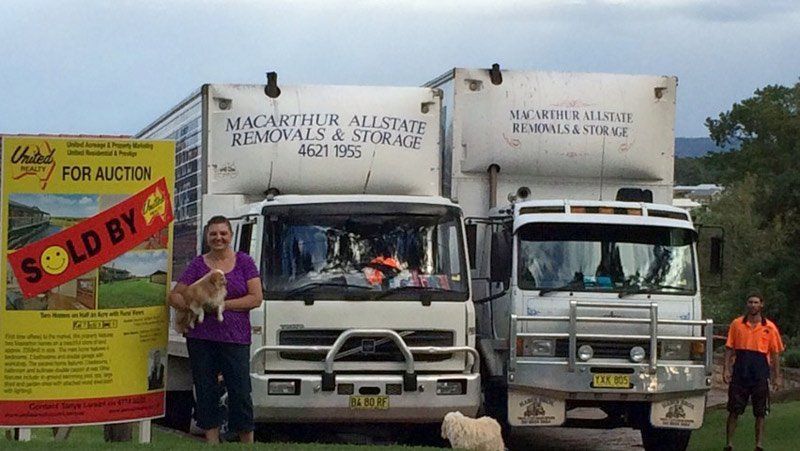 woman with dogs standing in front of trucks
