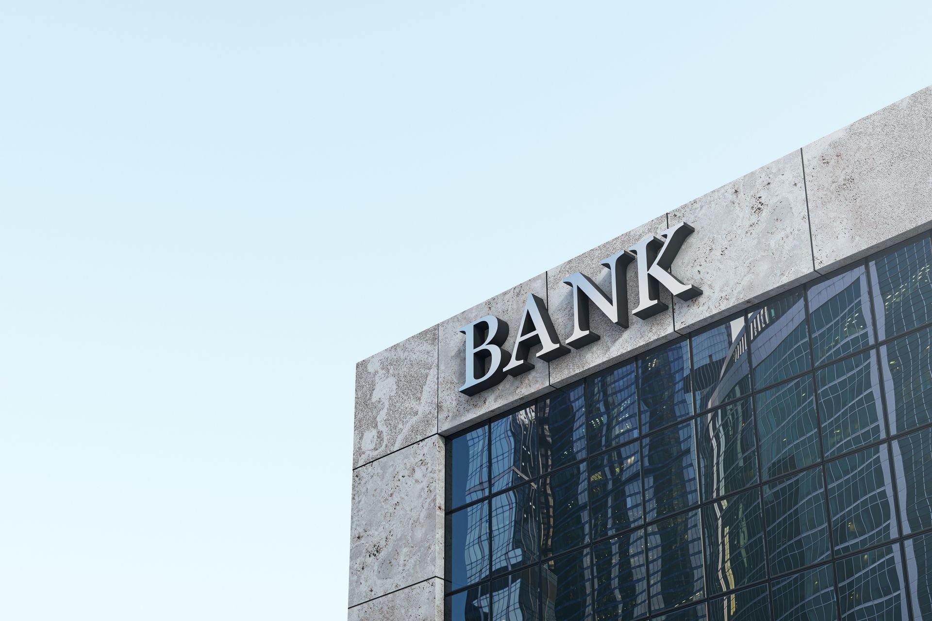 Modern bank building with stone facade and large glass windows under a clear blue sky