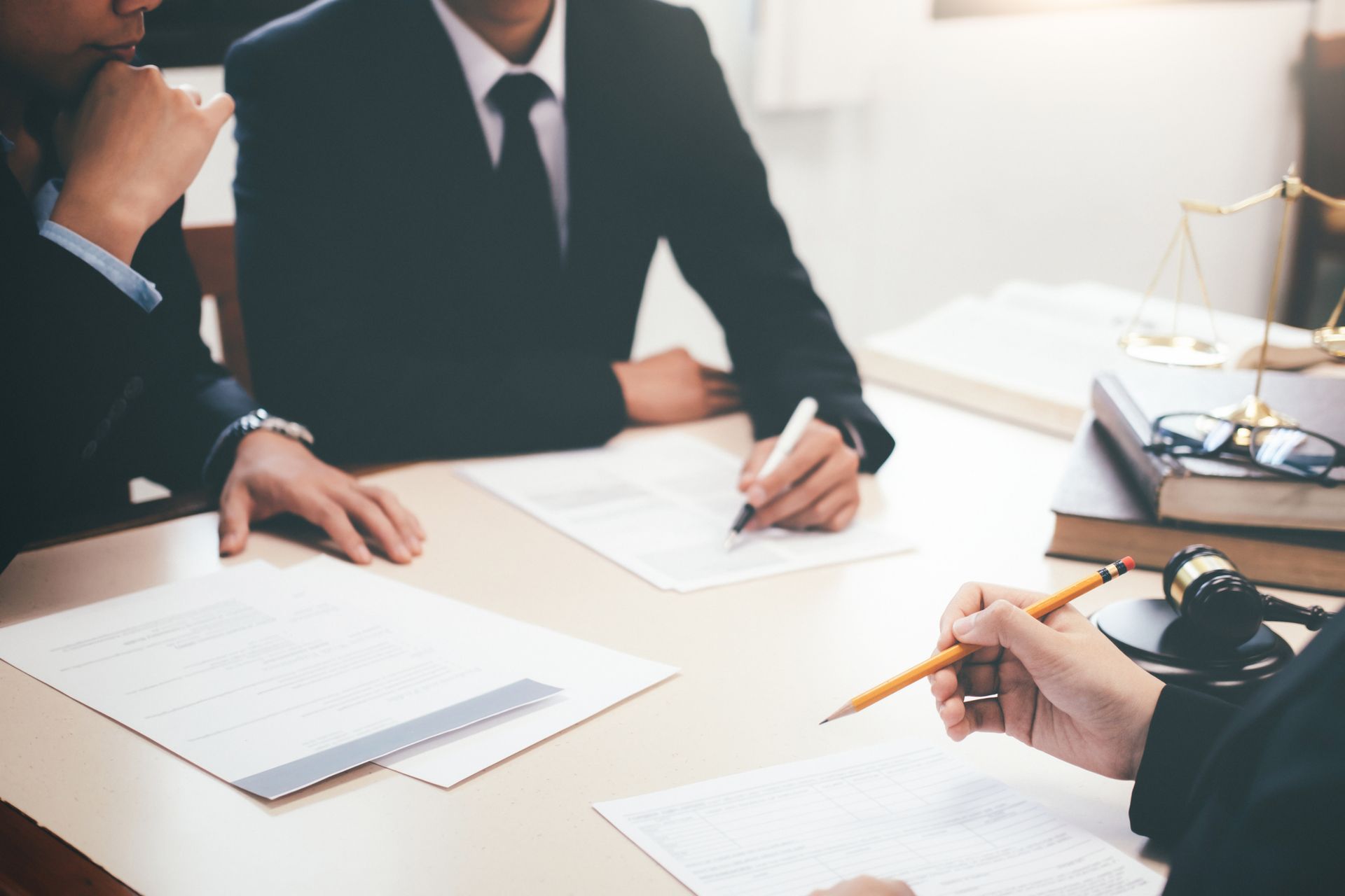 A work injury lawyer and attorney team are discussing workers' comp cases in a meeting.