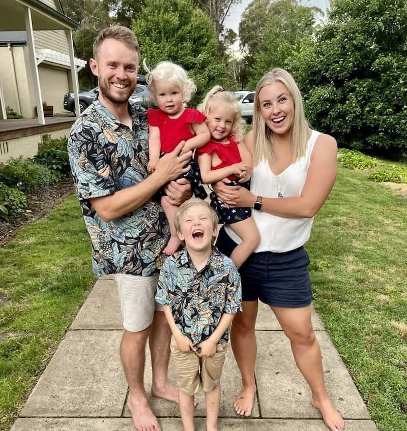 A Family is Posing for a Picture on a Sidewalk — Jaw Gear Dental Prosthetics in Bowral, NSW
