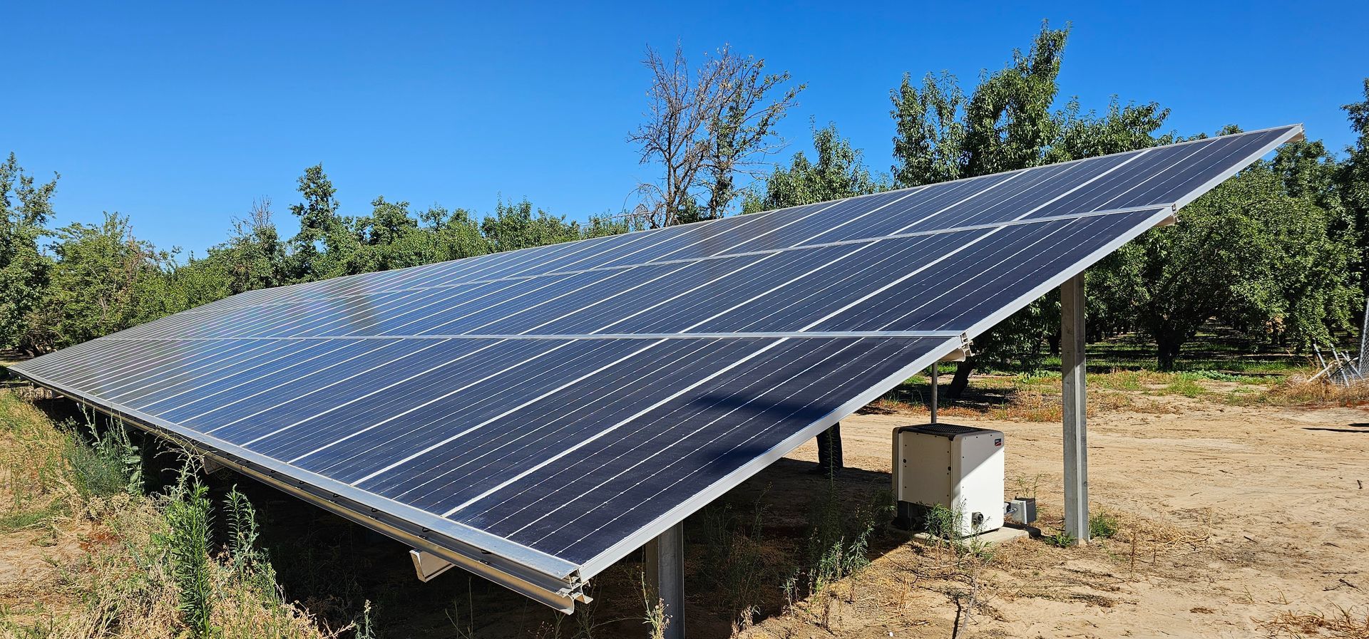 A large solar panel is sitting in the middle of a field.