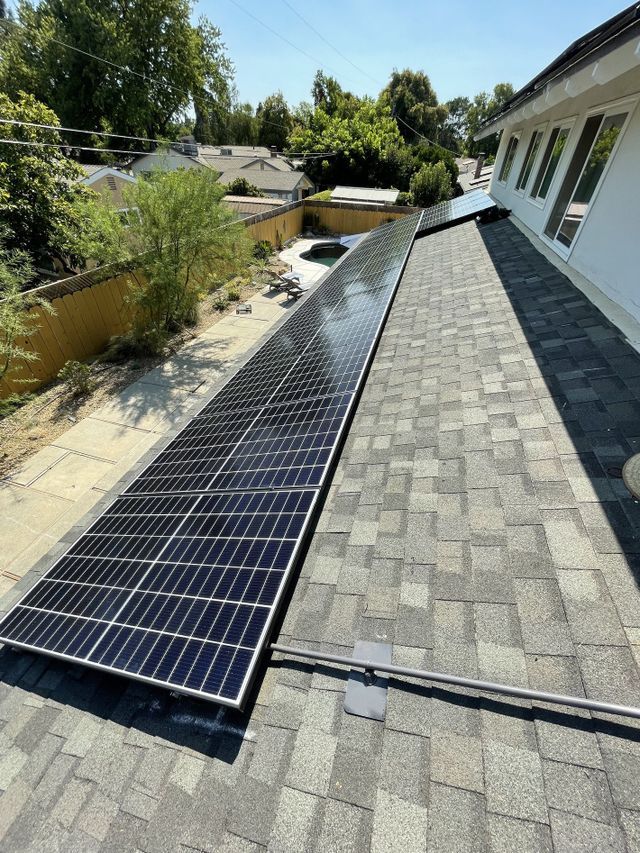 A row of solar panels on the roof of a house.