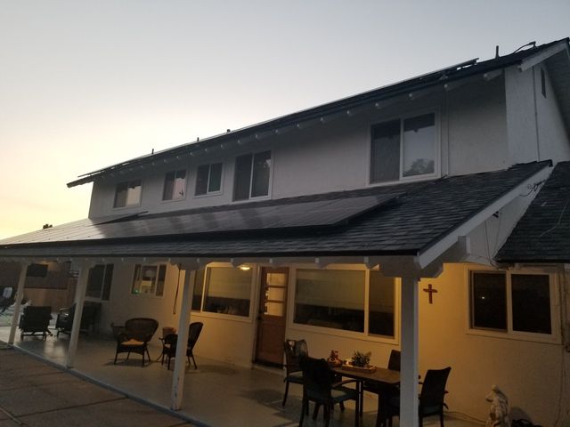A house with a porch and solar panels on the roof