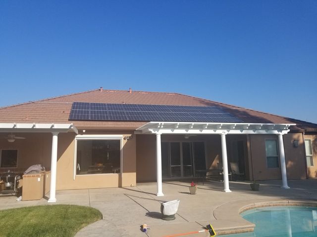 A house with a pool and solar panels on the roof