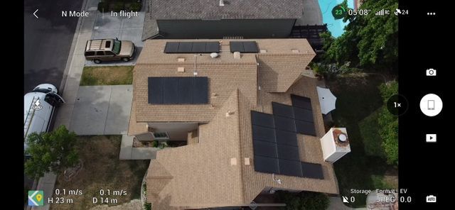 An aerial view of a house with solar panels on the roof