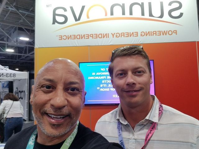 Two men are posing for a picture in front of a sign that says svonnu2