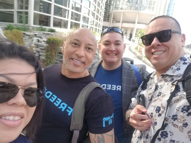 A group of people posing for a picture with one wearing a shirt that says breed