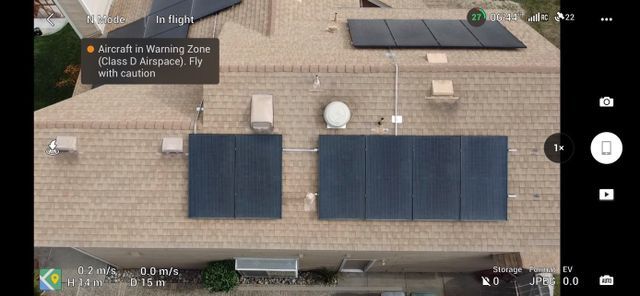 An aerial view of a house with solar panels on the roof.