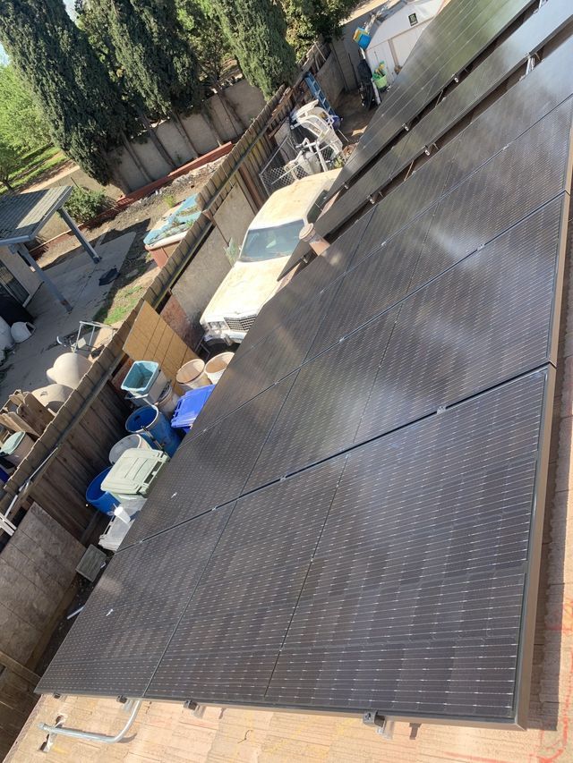 A bunch of solar panels are sitting on top of a roof.