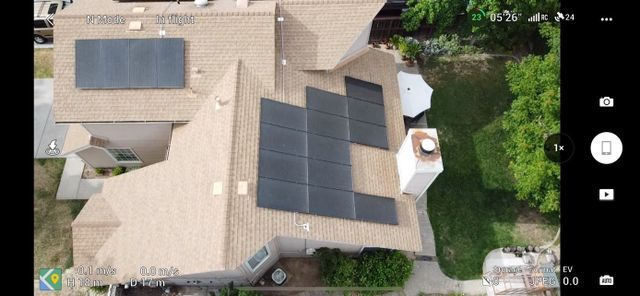 An aerial view of a house with solar panels on the roof.