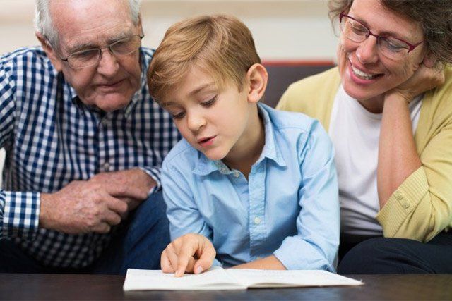 kid reading together with her grandparents