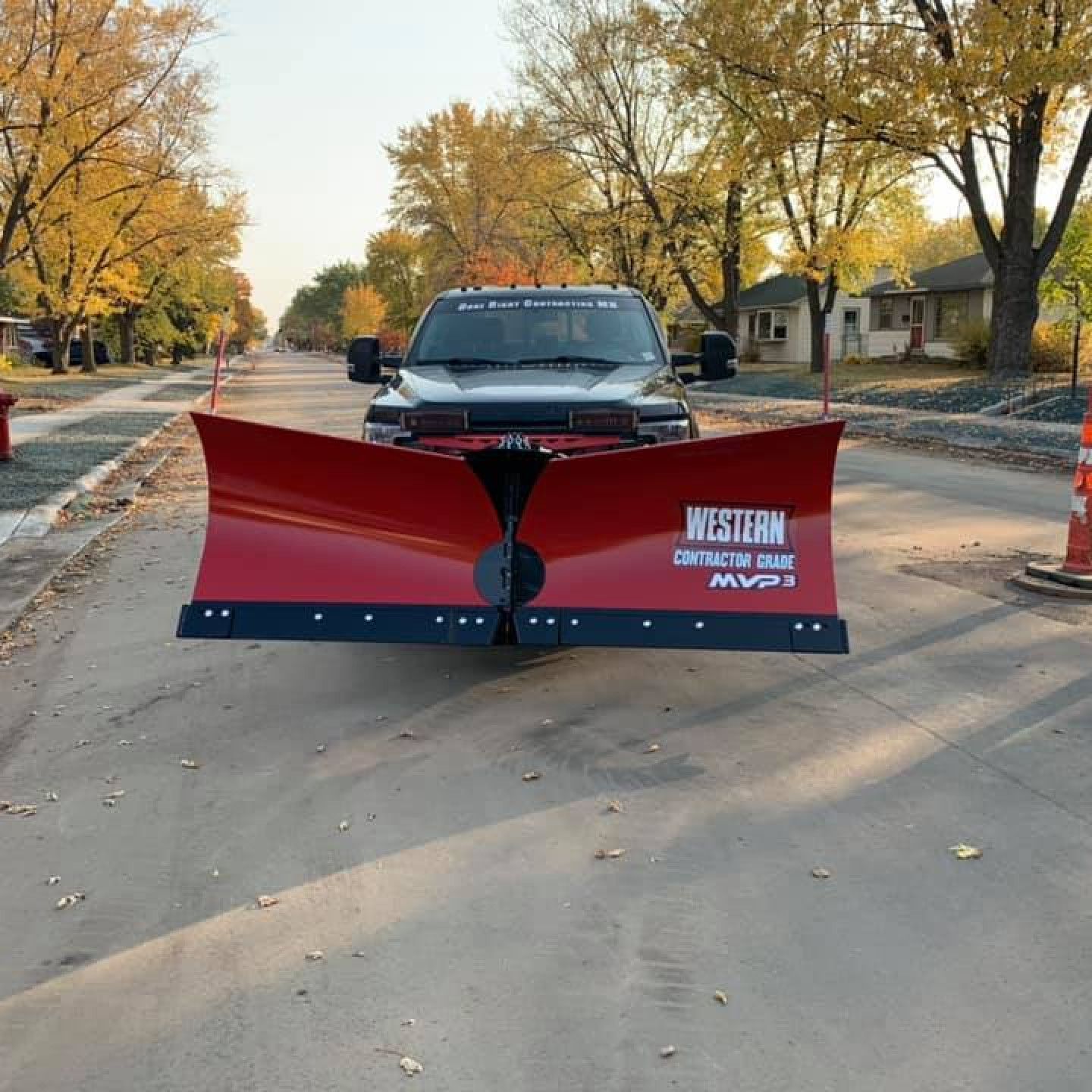 A western snow plow is parked on the side of the road