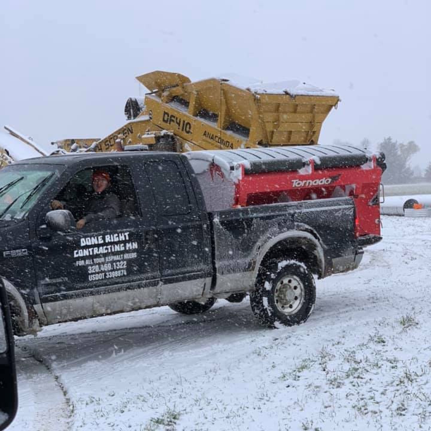 A black truck is parked in a snowy field