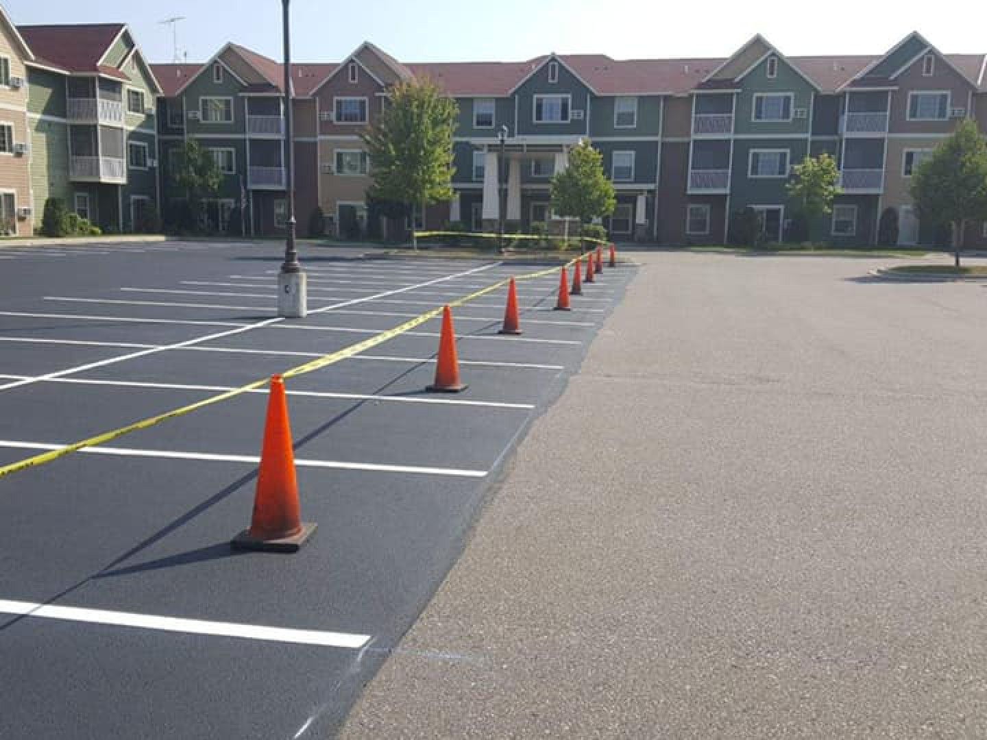 A parking lot with orange cones in front of a building