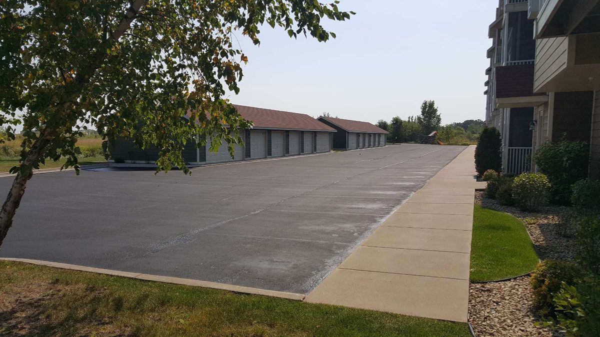 There is a large parking lot in front of a building.