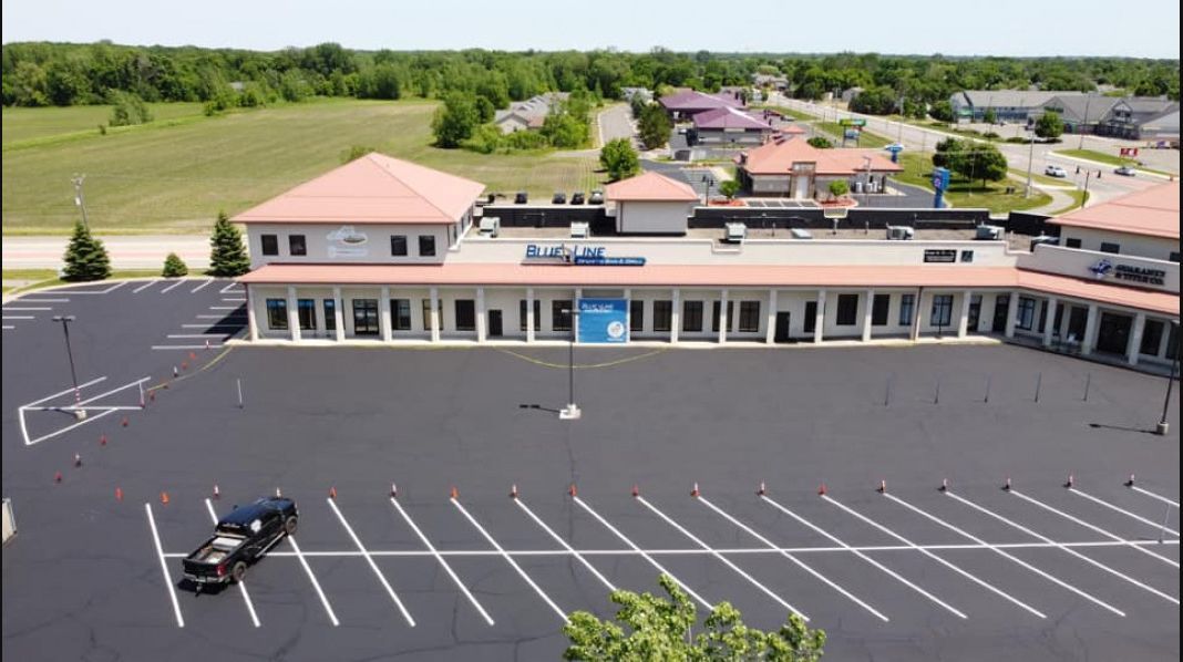 An aerial view of an empty parking lot in front of a building.