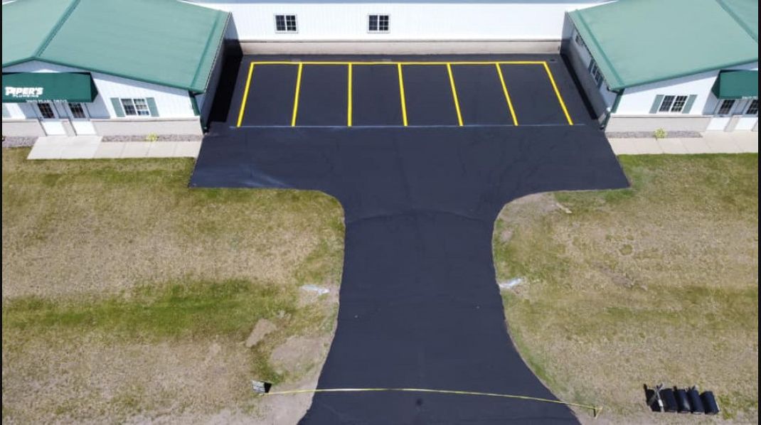 An aerial view of a parking lot with a building in the background.