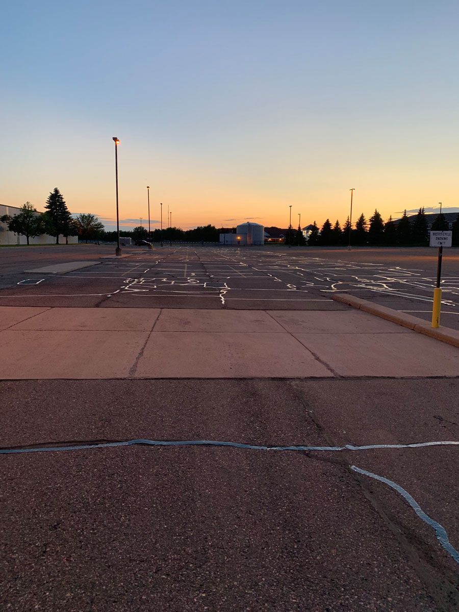 An empty parking lot with a sunset in the background