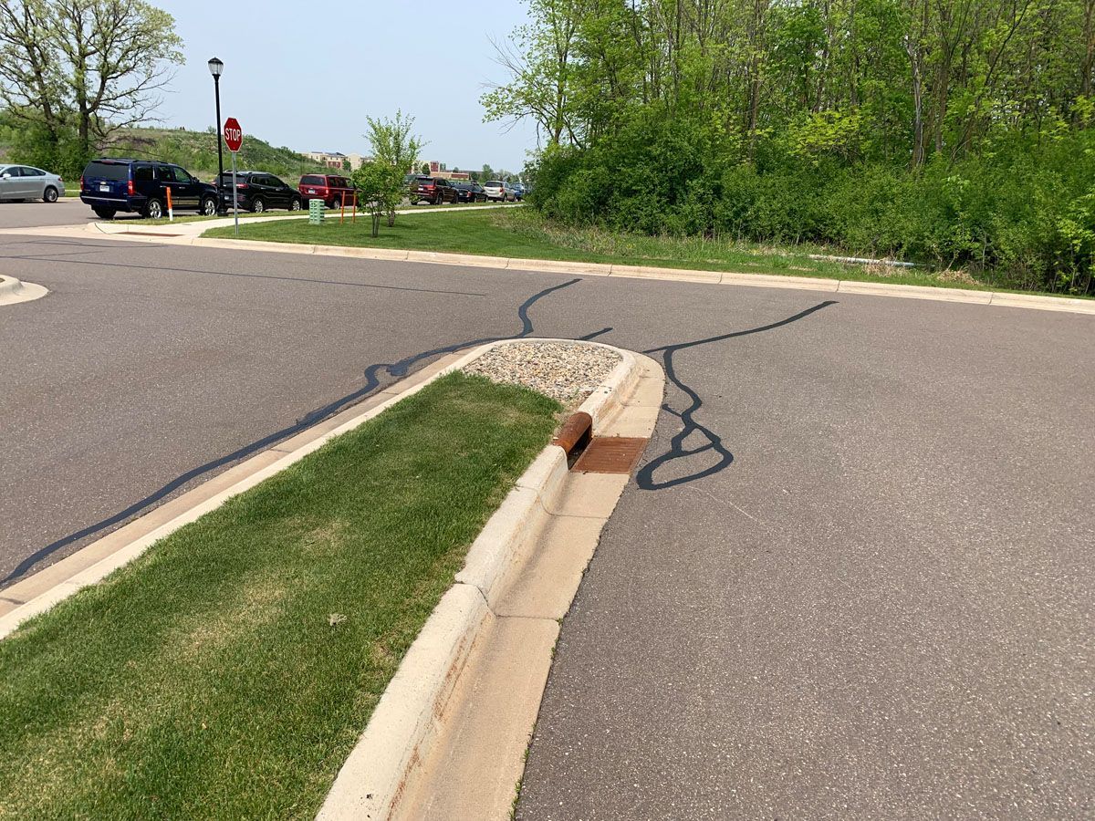 A road with a curb and a stop sign in the background