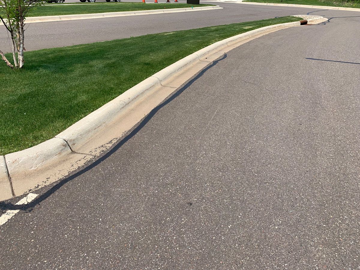 A road with a curb and grass on the side of it
