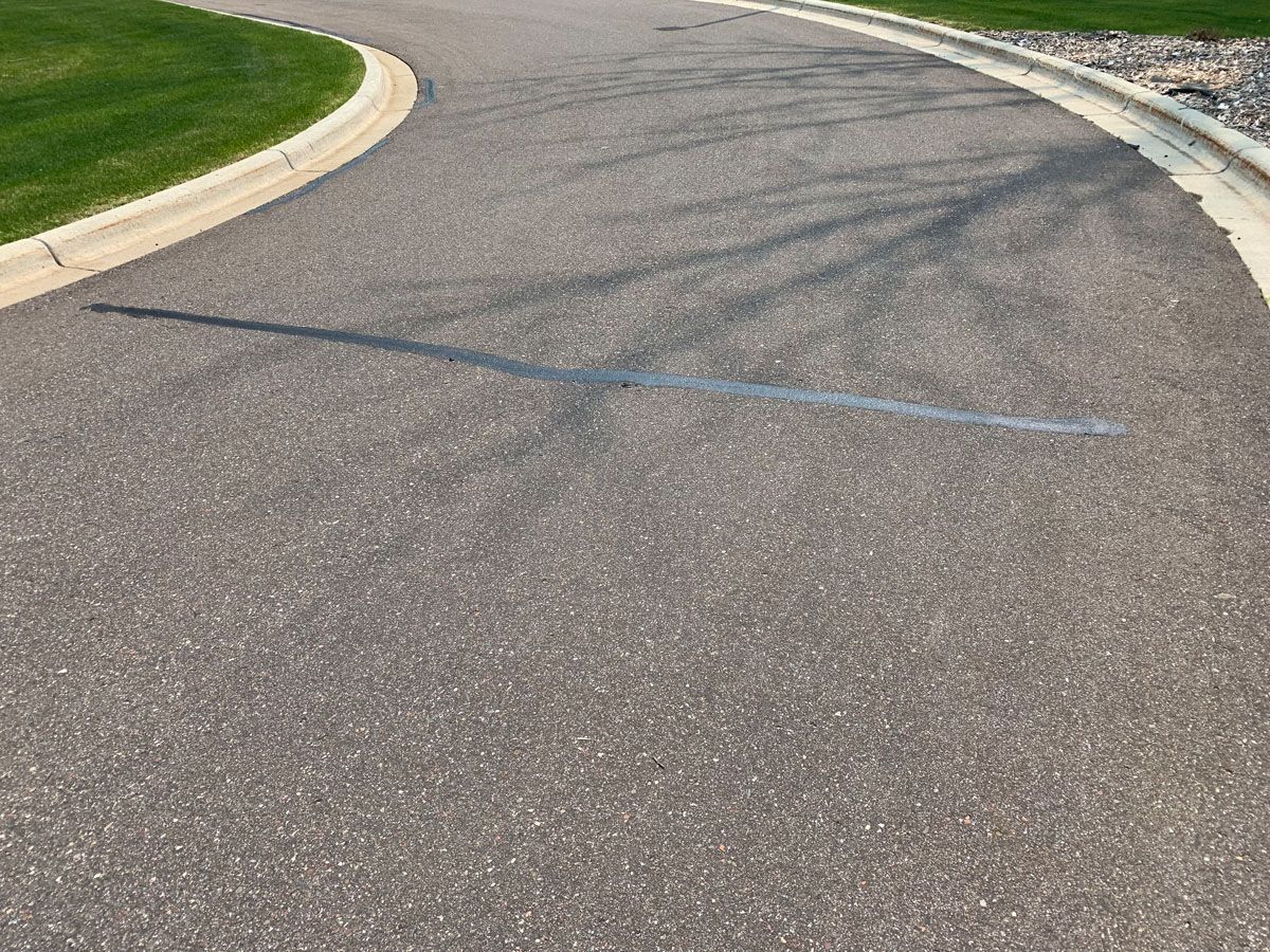 A close up of a road with a shadow of a tree on it.