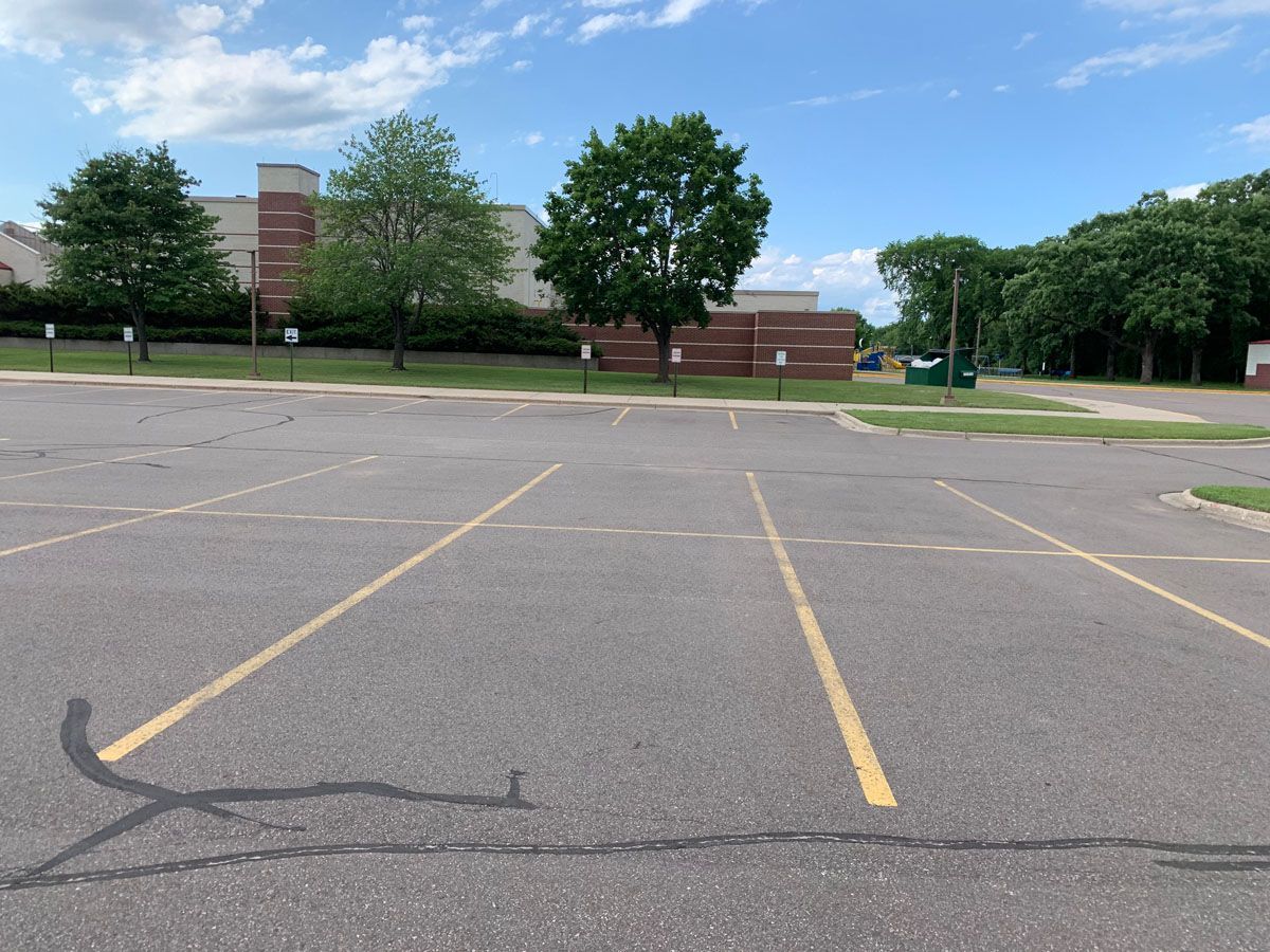 An empty parking lot with a building in the background