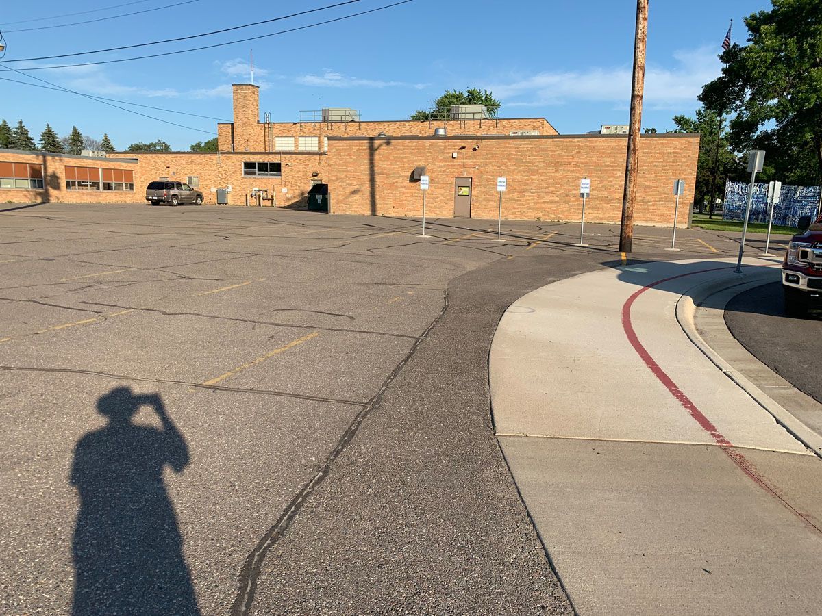 A shadow of a person taking a picture of a brick building