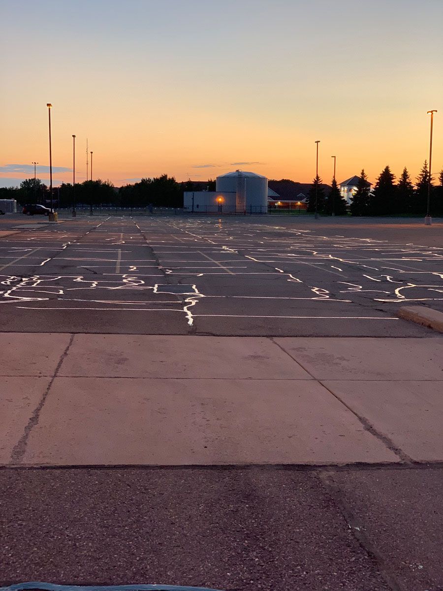 An empty parking lot with a sunset in the background