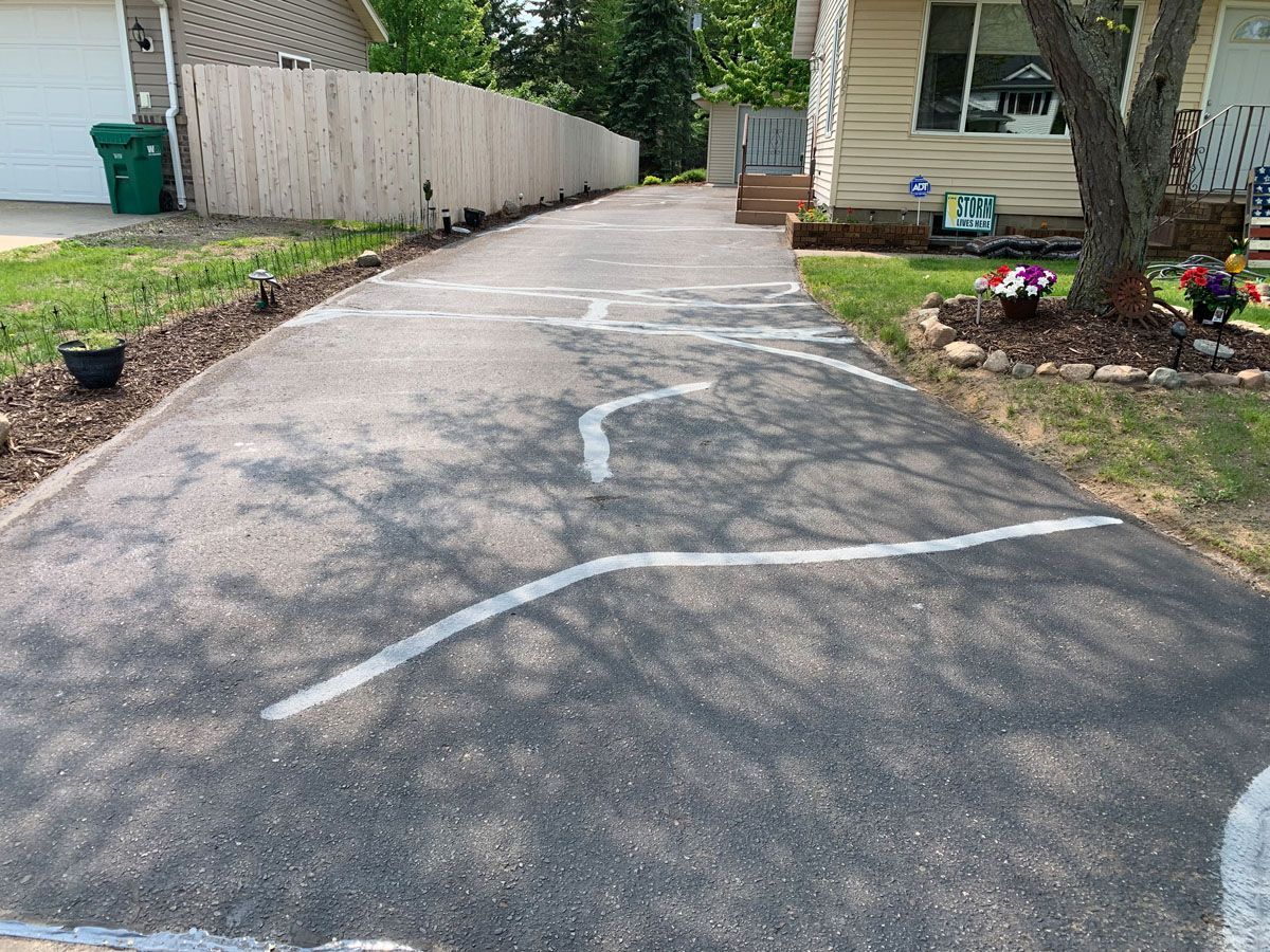 A driveway leading to a house with a white line on it.